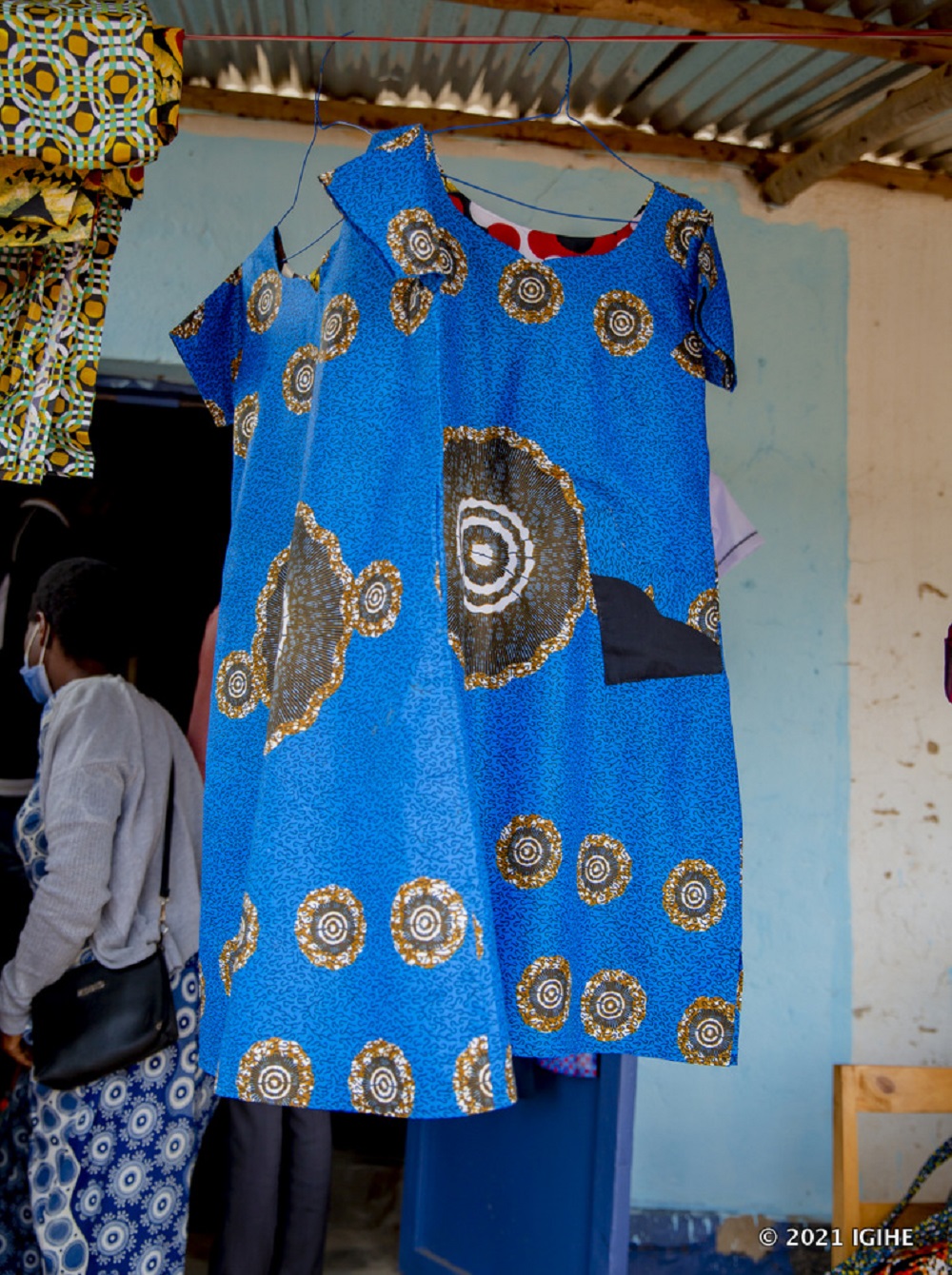 A beneficiary displaying one of garments made out of African print wrapper (Kitenge).