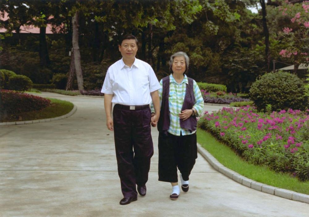 Xi Jinping takes a walk with his mother Qi Xin. (Xinhua)