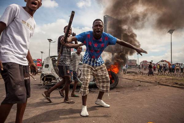 Demonstrators in front of a burning car during an opposition rally in Kinshasa on Sept. 19. More than a dozen people including three policemen were killed in protests on Monday.