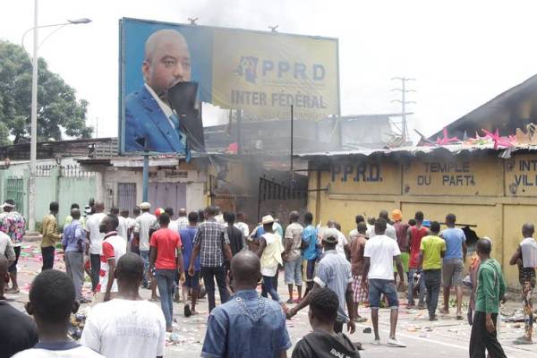 Congolese opposition supporters destroy a billboard of President Joseph Kabila during a march to press the president to step down in the Democratic Republic of Congo's capital Kinshasa, Sept. 19.