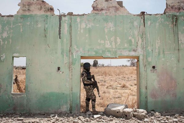 A Nigerian soldier stands amidst the ruin of the Government Girls' Secondary School Chibok in Borno on March 25, 2016. Boko Haram's use of child bombers has increased over the last three years, Unicef says.