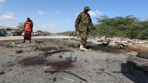 A soldier inspects the scene of an explosion where a general and his bodyguards were killed