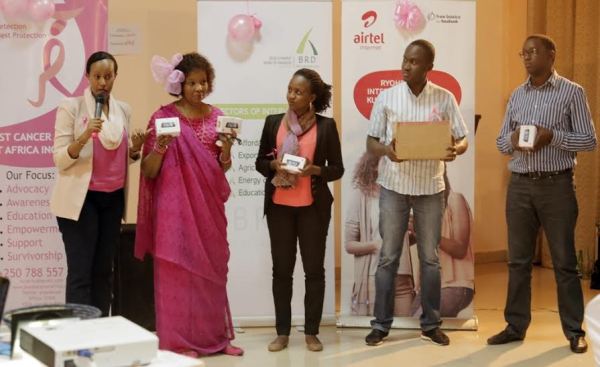 Airtel Rwanda Head of CSR and Coorporate Communications hands over handsets to help in Breast Cancer Awareness