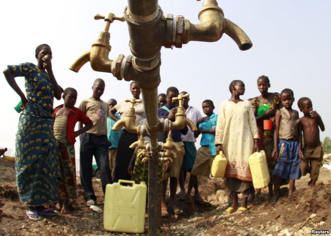 Congolese refugees, displaced by fighting between the Congo army and rebel group Allied Democratic Forces (ADF), gather around dry water taps at a transit camp southwest of Kampala, July 17, 2013.
