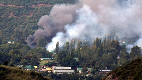 Smoke billows out from inside an Indian Army base which was attacked by suspected rebels in Uri