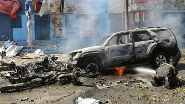 A firefighter tries to extinguish fire from the wreckage of a burning vehicle following an attack on a restaurant by the Somali Islamist group al Shabaab in the capital Mogadishu, Somalia.