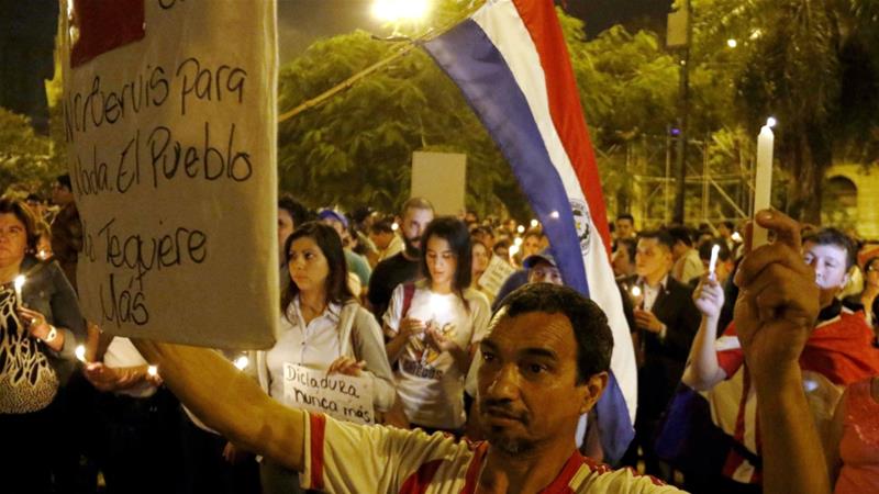 People participate in a demonstration against the of re-election bid of President Cartes