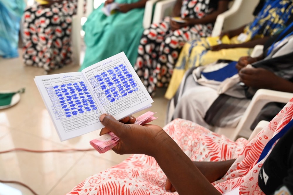 Women making contributions in a saving group. 