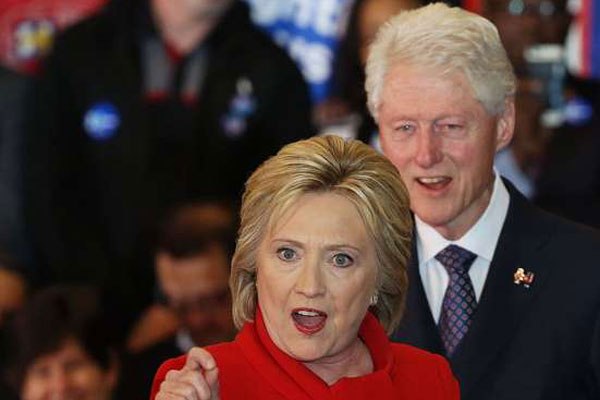 Democratic presidential candidate former Secretary of State Hillary Clinton speaks to supporters as Former U.S. president Bill Clinton looks on during her caucus night event in the Olmsted Center at Drake University on February 1, 2016 in Des Moines, Iowa.