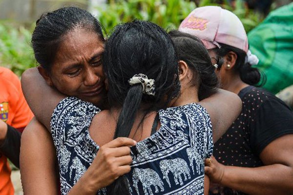 A woman cries as she is reunited with her family amid the rubble left by mudslides following heavy rains in Mocoa, southern Colombia on April 2, 2017.