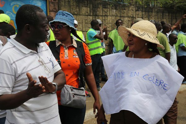 A woman wearing a T-shirt reading "angry woman" (right) talks with a man as members of the Gabonese opposition demonstrate in Libreville on July 23, 2016. Gabon President Ali Bongo Ondimba has warned of possible unrest during the August 27 election which he said was the "strategy" of the opposition.