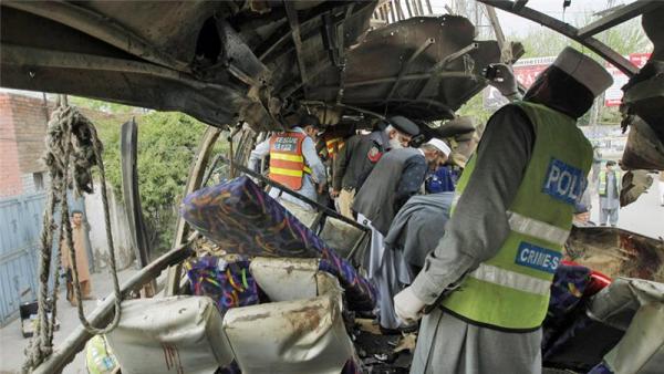 Pakistani security staff examine the bus following a blast in Peshawar on Wednesday