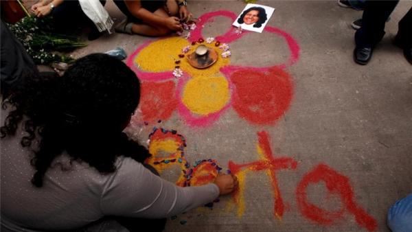Activists draw a flower on the floor for environmental rights activist Berta Caceres