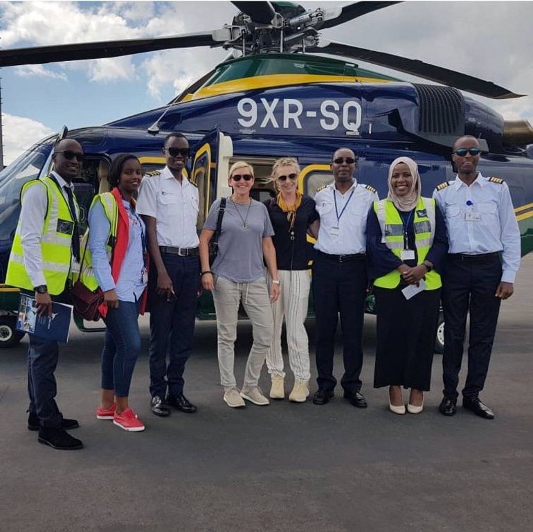 TV Host Ellen DeGeneres and wife Portia de Rossi posing with Akagera Aviation employees