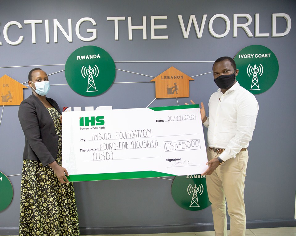 Gérardine Umutesi, the Deputy Director General of Imbuto Foundation and Amida Azeez, Acting Managing Director of IHS exchanging a dummy cheque.