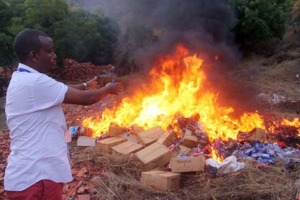 An officer from the anti-counterfeit agency sets ablaze thousands of counterfeit ball pens in this picture taken on April 10, 2016 after the Mombasa court ordered the destruction of fakes.