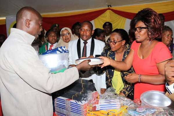 From right: Nairobi Women Representative Rachel Shebesh, Youth and Gender Affairs Cabinet Secretary Sicily Kariuki and Nairobi Senator Mike Sonko hand household items to a survivor of the collapsed Huruma building. Foodstuff were stolen from a store where the victims are being accommodated.