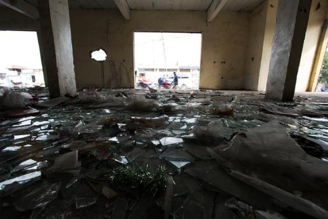 Broken glass is pictured on the floor of a looted store following violent protests in Kinshasa, Democratic Republic of Congo, January 23, 2015.