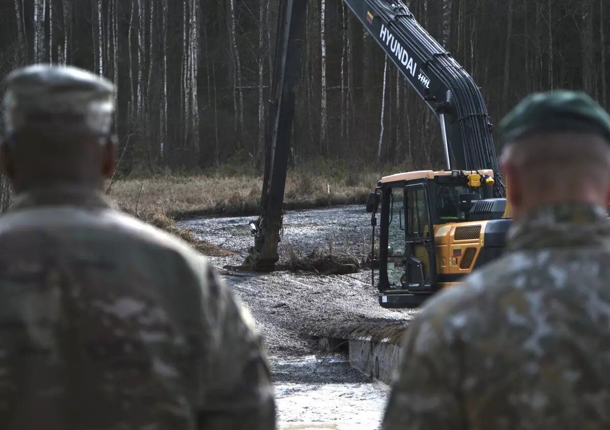 Heavy equipment is used to retrieve a submerged vehicle with the bodies of U.S. soldiers in a swamp near a training area near Pabadre, Lithuania.