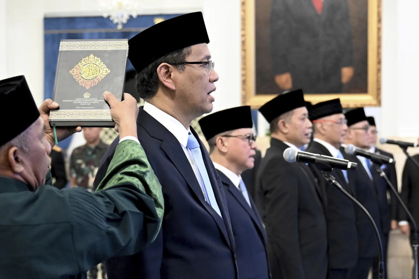 Indonesian Presidential Palace, an Islamic cleric holds a holy book of Quran over the head of the new Finance Minister Purbaya Yudhi Sadewa as he takes his oath with other newly appointed ministers and vice ministers during a swearing in ceremony at the State Palace in Jakarta, Indonesia, Monday, September 8, 2025.