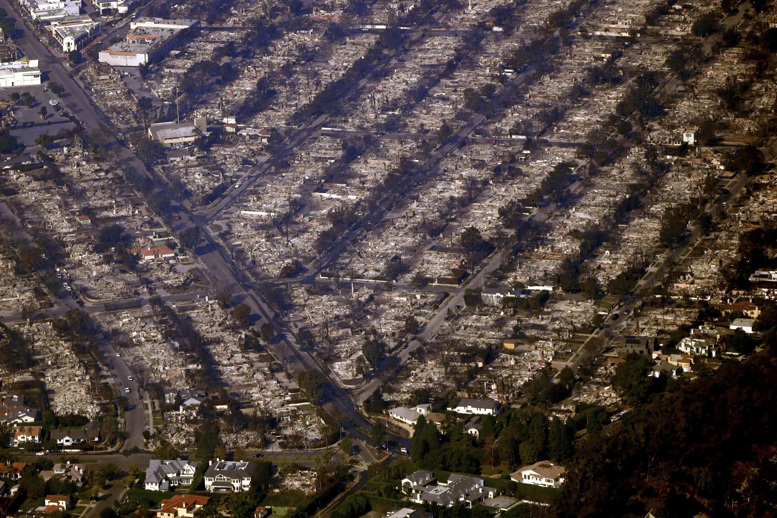 Homes are seen burned while a few still stand, Thursday, January 9, 2025, in the Pacific Palisades section of Los Angeles.