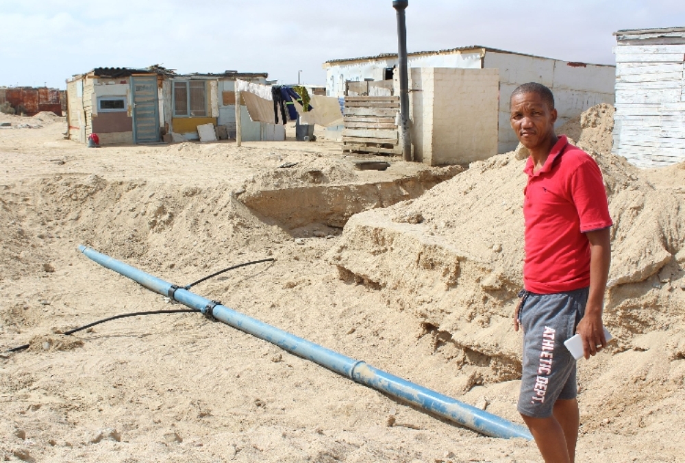 DRC community leader and activist Ambrosius Marsh shows off some of the construc- tion work taking place in the informal settlement.