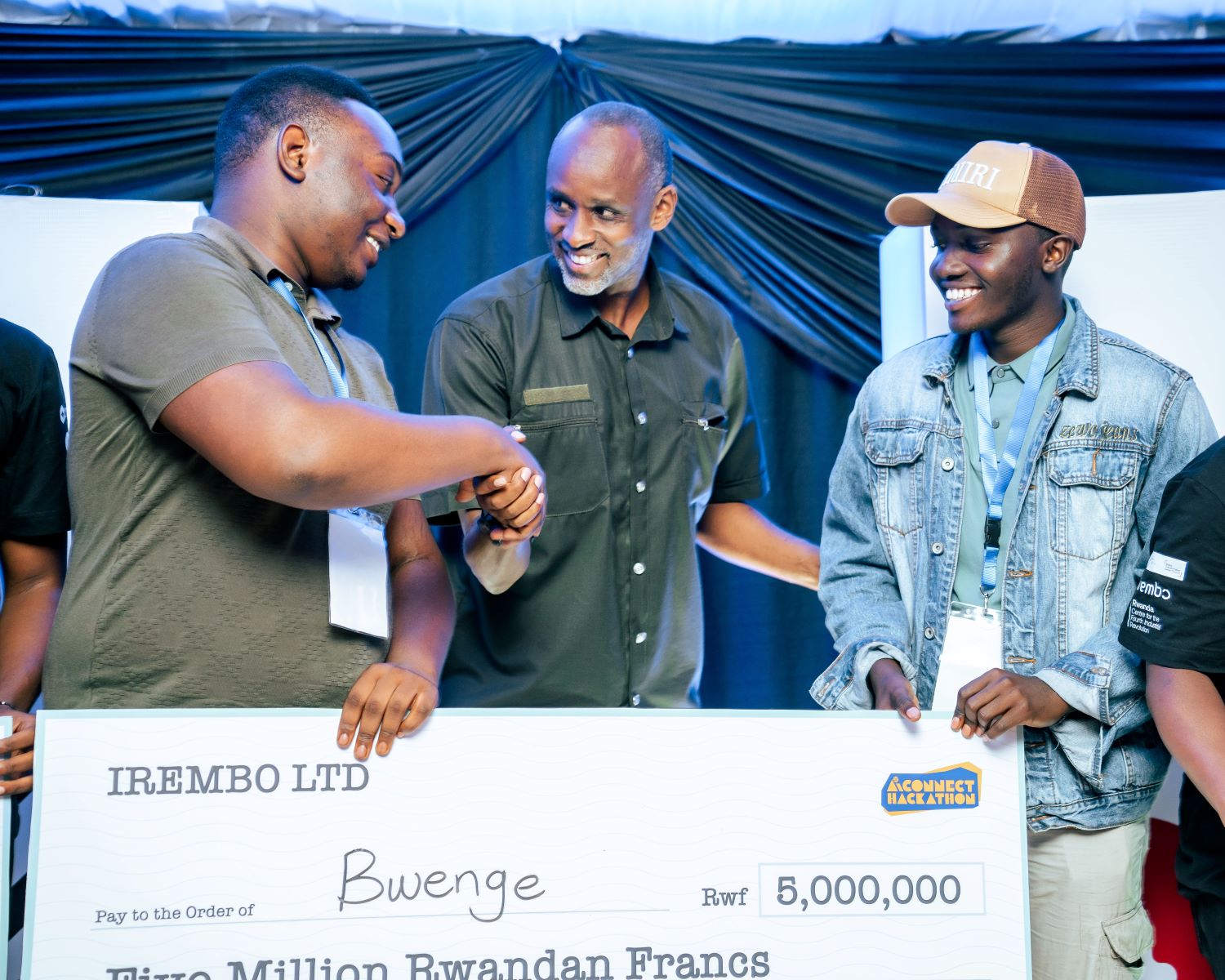 Cedric Izabayo (left) and Libériste Clarence (right) pose for a photo with Rwanda Information Society Authority (RISA) CEO Innocent Muhizi during the awarding ceremony at Irembo Campus in Nyarutarama.