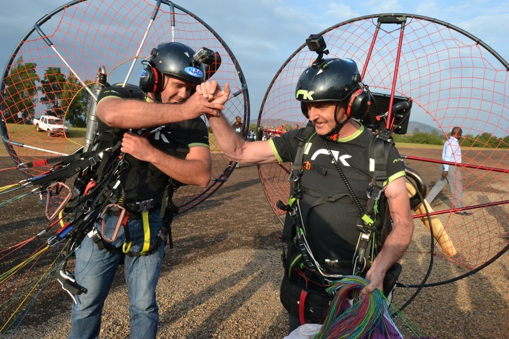 Members of the Rwanda Flying Club, Alain Julot and Sebastien Houben demonstrating paramotoring to local media at the Huye aerodrome.