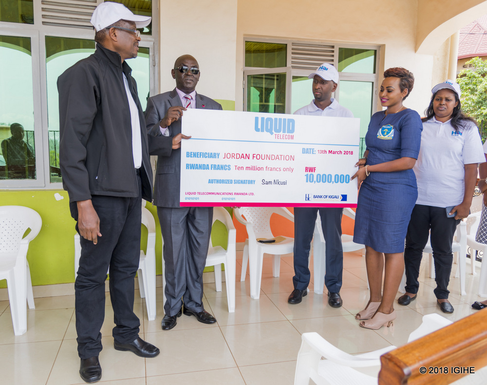Liquid Telecom Rwanda's Sam Nkusi hands a cheque to Jordan Foundation Founder Vanessa Bahati