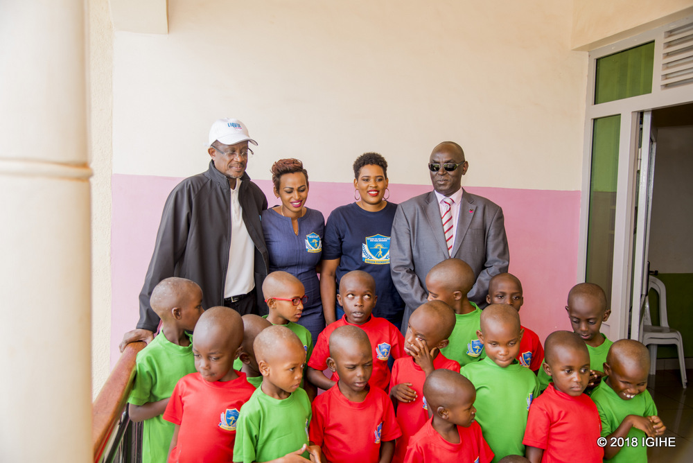 Liquid Telecom Rwanda's Sam Nkusi (L) and the chairman of Zigama CSS, Dr. James Ndahiro (R) alongside Jordan foundation officials pose for a group photo with children supported by the foundation