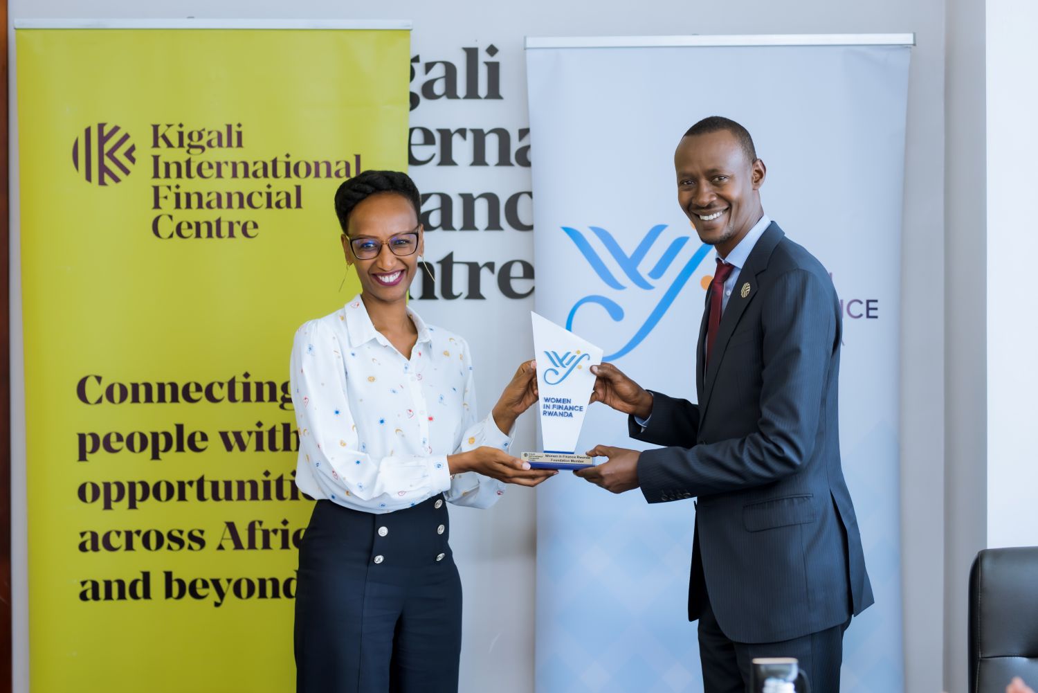 Rwanda Finance Limited CEO, Nick Barigye, receives a Women in Finance Rwanda (WIFR) membership trophy from the foundation's co-founder, Belinda Bwiza, after signing the membership charter on Thursday, April 17, 2025.