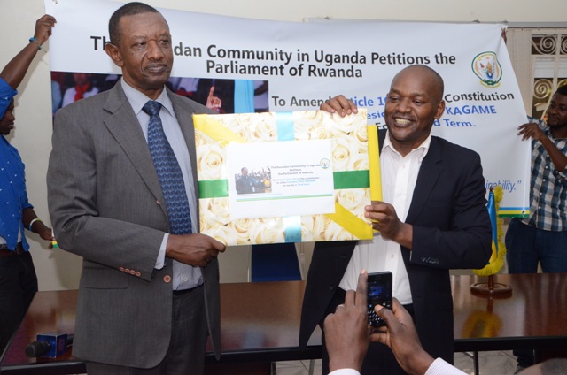LEFT: Rwanda's High Commissioner to Uganda Frank Mugambage receives the petition from Cilidio Ubitsemunda, a leader of the Rwandan community in Uganda.