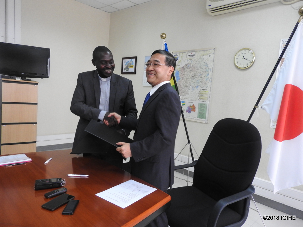 Ambassador of Japan in Rwanda, Takayuki Miyashita and Nzuki VTC's headmaster, Father Gerard Hakizimana, after signing the grant contract