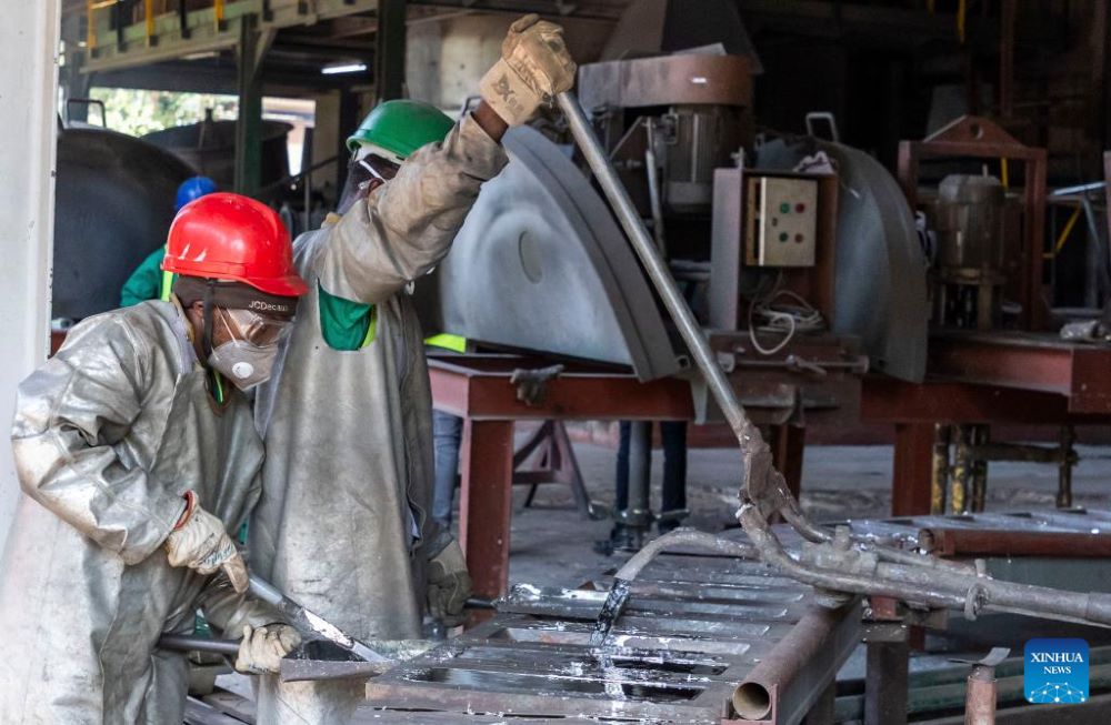 Workers inject molten tin into molds for casting at a smelter's facility in Kigali, Rwanda, Nov. 30, 2023. (Photo by Cyril Ndegeya/Xinhua)