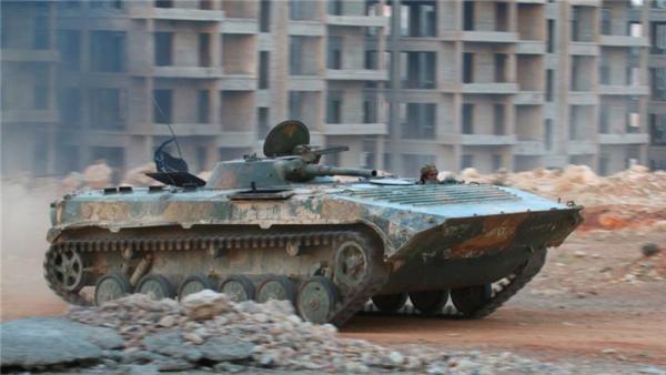 A Jabhat Fateh al-Sham fighter rides in an armoured vehicle in southwestern Aleppo