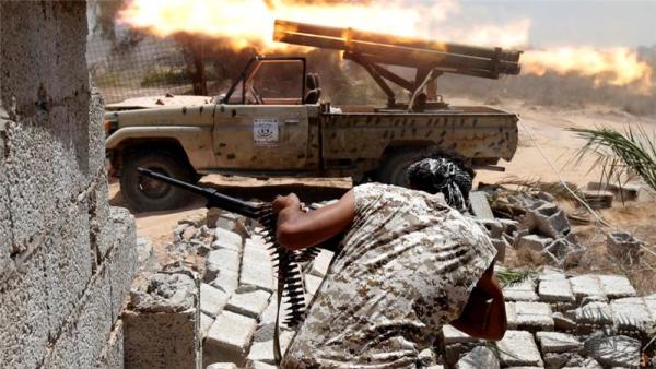 Libyan forces allied with the UN-backed GNA government fire weapons during a battle with ISIL fighters in Sirte