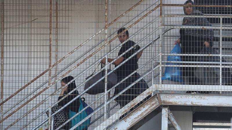 Refugees carry their belongings during the police operation