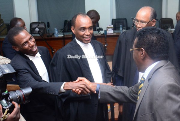 Museveni lawyer Sebidde Kiryowa and Information minister Jim Muhwezi shake hands after the Supreme Court ruling on the election petition in Kampala yesterday.