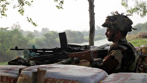 An Indian soldier keeps guard from a bunker near the border with Pakistan in Abdullian