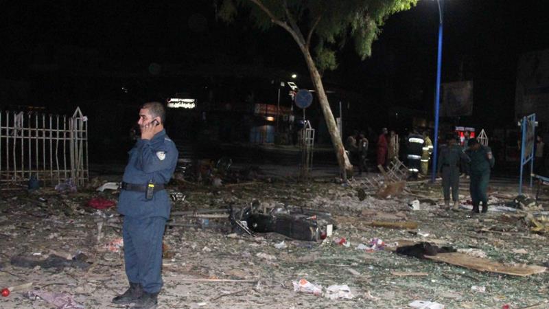 Afghan security officials inspect the scene of bombings that killed civilians in Kandahar