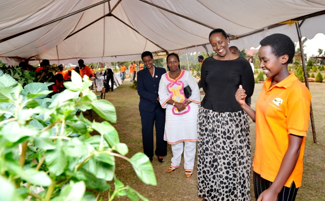 First Lady with young girl explaining her stand at the youth village