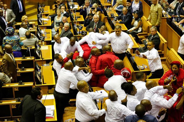 Security officials force out members of South African opposition party Economic Freedom Fighters during President Jacob Zuma's State of the Nation Address to parliament in Cape Town on February 9, 2017.