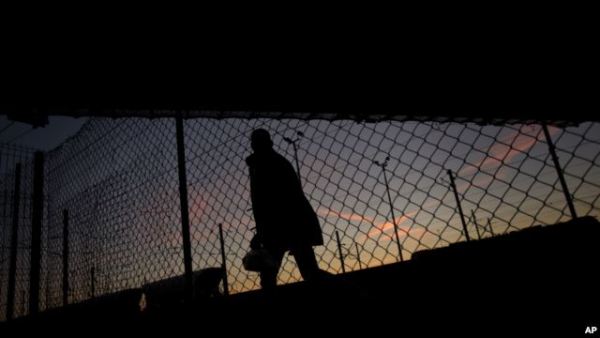 A migrant is seen walking after crossing a fence as he attempts to access the Channel Tunnel in Calais, northern France. The new controls will be part of larger security measures around the climate conference 