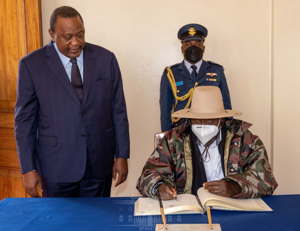 President Museveni signing a guest book in Kenya. 