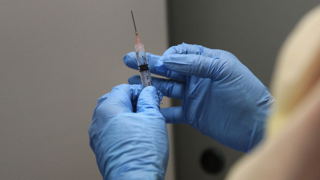 A Liberian pharmacist prepares an Ebola vaccine.