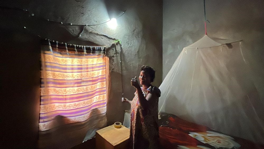 The local resident can’t help but give the PolyU service-learning team a thumbs up as the gloomy room is illuminated by the solar-powered lamp. (Photo by Su Ting)