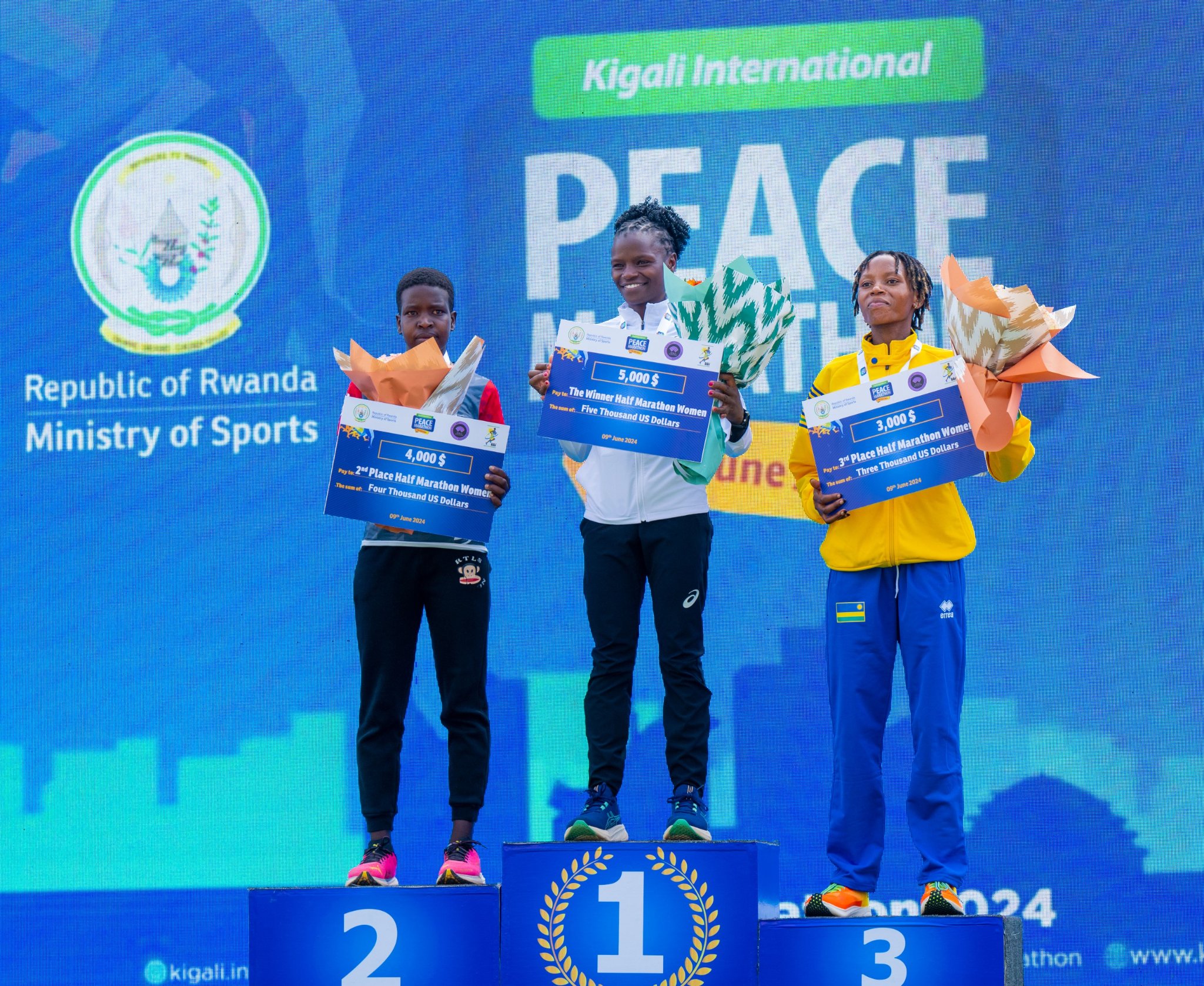 Winfridah Moraa, Vivian Jepkogei and Emeline Imanizabayo awarded after their victory in the women's half marathon category.