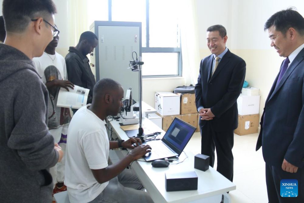 A local student operates devices as Chinese Ambassador to Rwanda Wang Xuekun (2nd R) looks on in a laboratory of the Luban workshop at IPRC Musanze in Northern Province, Rwanda, Nov.18, 2023. (Photo by Huang Wanqing/Xinhua)