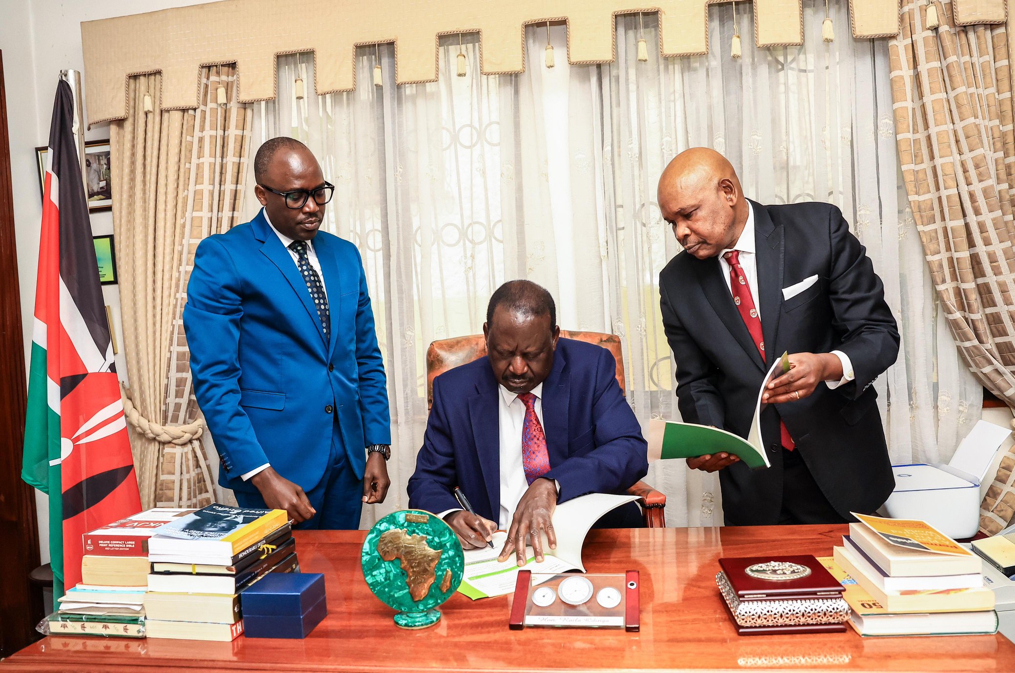 Raila Odinga (center) signs the AUC Chair application documents on Saturday, July 27, 2024.