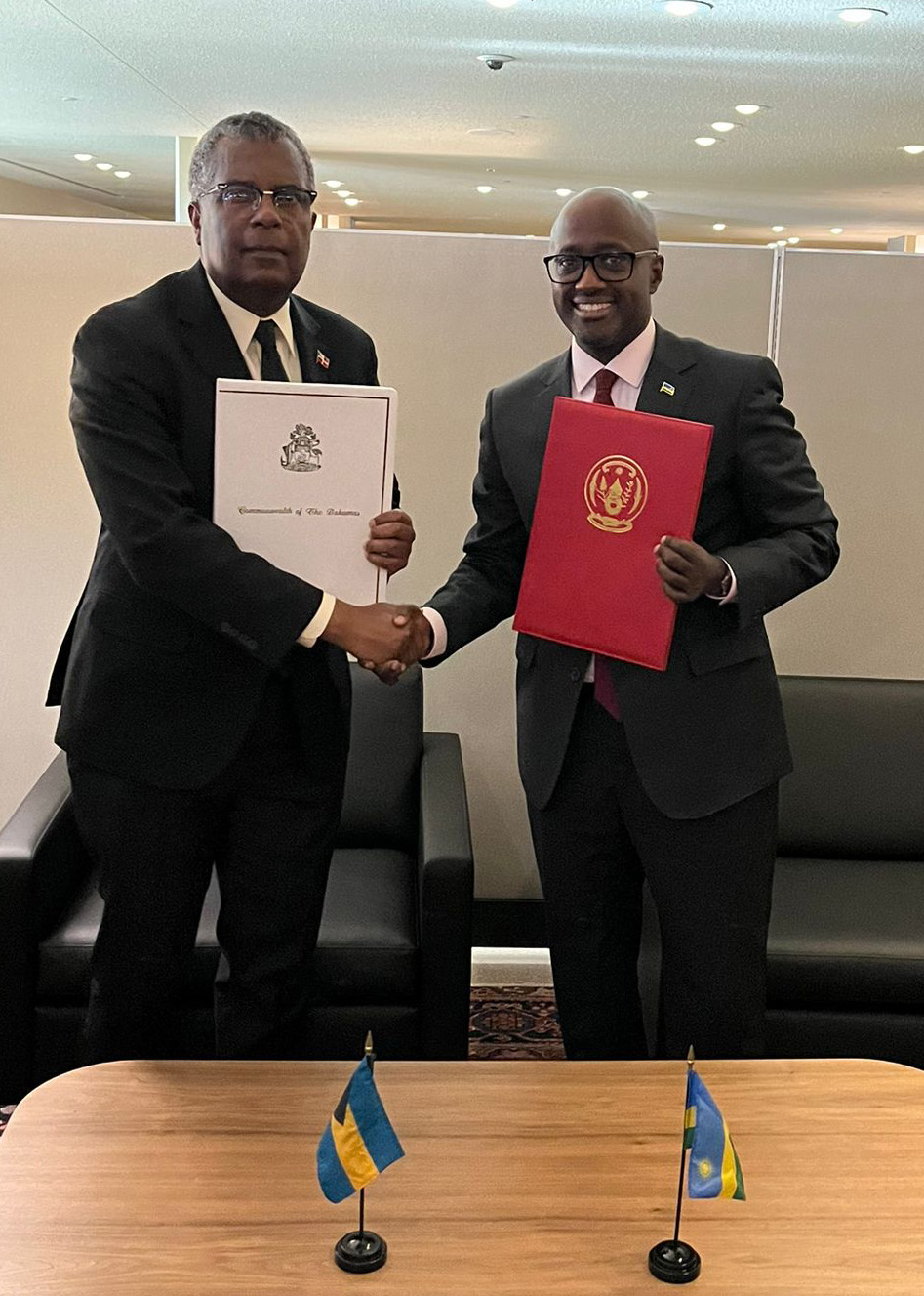 Minister Nduhungirehe exchanging documents with his counterpart of The Bahamas.